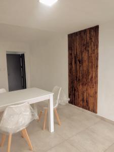 een witte tafel en stoelen in een kamer met een houten deur bij Casa Tulia in Tolosa