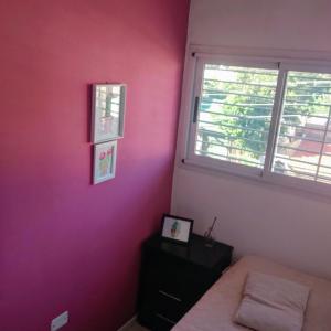 een slaapkamer met roze muren, een bed en een raam bij Casa Tulia in Tolosa