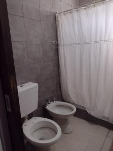 een badkamer met een toilet en een douchegordijn bij Casa Tulia in Tolosa