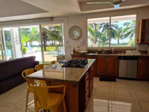 a kitchen with a island with a stove top at Casa Carey Lajas Pty Exclusive Beachfront Villa in Cabrera