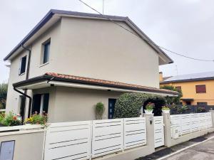 a white fence in front of a house at New Bedrooms Mamma Gigetta in Noventa di Piave