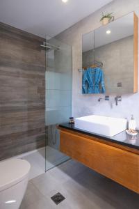 een badkamer met een wastafel, een toilet en een spiegel bij Glaros Casa Verde - Cozy flat with Garden near Beach in Kato Daratso