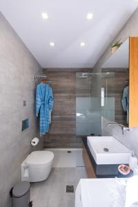 ein Badezimmer mit einem Waschbecken, einem WC und einer Badewanne in der Unterkunft Glaros Casa Verde - Cozy flat with Garden near Beach in Kato Daratso