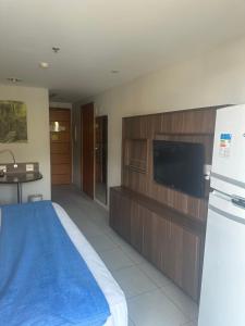 a room with a bed and a tv and a refrigerator at Suíte com sacada Hotel Mercure in Nova Iguaçu