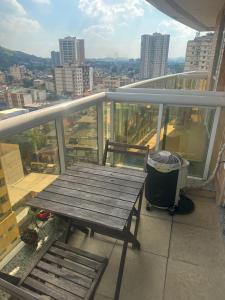 a wooden table and a trash can on a balcony at Suíte com sacada Hotel Mercure in Nova Iguaçu