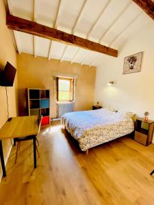 a large bedroom with a bed and a desk at La Maison M 6pers in Valréas
