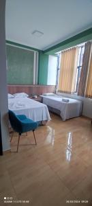 una camera con due letti e una sedia di casa sol residencial tarapoto a Tarapoto