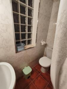 a bathroom with a toilet and a sink and a window at VFT DOÑA ELVIRA SIERRA in Virgen de la Cabeza