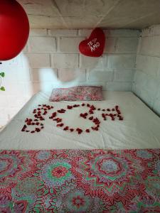 a bed with a bunch of rose petals on it at Cabaña Palmeras del Viento in San Bernardo del Viento