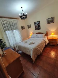 a bedroom with a bed and a table and a window at VFT DOÑA ELVIRA SIERRA in Virgen de la Cabeza