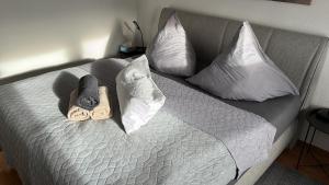 un letto con due pantofole e cuscini sopra di Apartment 3 ABG69 - ideal für Familien und Geschäftsreisende a Gera