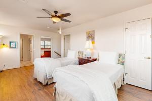 two beds in a bedroom with a ceiling fan at Casa Austin in Fredericksburg