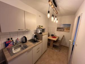 una pequeña cocina con fregadero y microondas en Apartment 3 ideal für Familien und Geschäftsreisende ABG69 en Gera