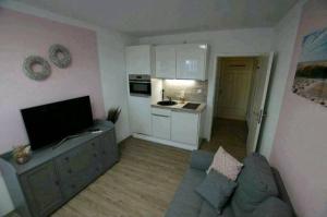 博尔库姆Haus Kleeblatt klein的客厅里有一张沙发和一个厨房