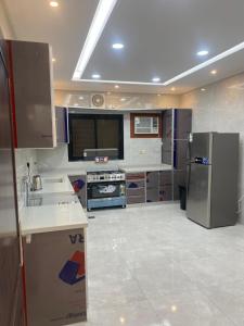 a kitchen with a sink and a refrigerator at شقق ضيافة رغد 2 in Al Madinah