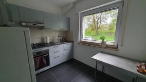 a kitchen with white cabinets and a window at Apartment nahe Cannstatter Wasen und Stadion in Stuttgart