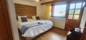een slaapkamer met een bed en een groot raam bij Hotel Villa Javier VDL in Villa de Leyva