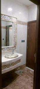 a bathroom with a sink and a large mirror at فندق نجمة العزيزية Star AL Aziziyah in Makkah