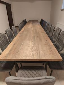 une grande table en bois entourée de chaises dans l'établissement Dworek Zaporów, 