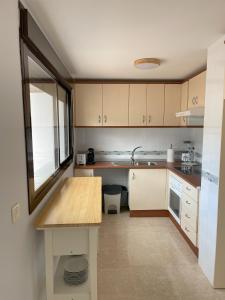 a kitchen with wooden cabinets and a counter top at Ático Carboneras con fantástica terraza in Carboneras