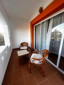 Zimmer mit 2 Stühlen und einem großen Fenster in der Unterkunft appartamento nel resort Domina in Sharm El Sheikh