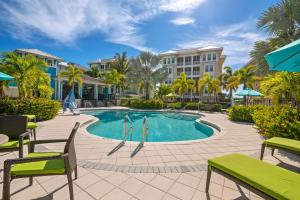 a pool at the resort with chairs and condos at Bungalow at Margaritaville! Less than 1 Mile to AMI! in Bradenton