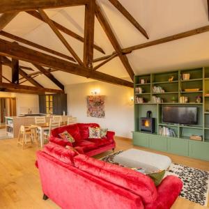 uma sala de estar com um sofá vermelho e uma lareira em Wood Cottage em York