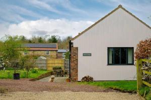 ein weißes Haus mit einem Hund im Hof in der Unterkunft Wood Cottage in York