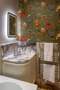 ein Badezimmer mit einem Waschbecken und einer Blumentapete in der Unterkunft Wood Cottage in York + 12 Fotos