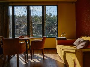 a living room with a couch and a table at Bakony Deep Forest Vendégház in Bakonyszentlászló