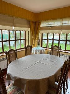 a dining room with a table and chairs and windows at El Gerbal in Villahoz