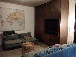 a living room with a couch and a flat screen tv at Charmante villa des années 30 in Abeiche