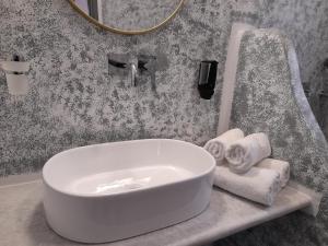 a bathroom with a white tub and towels on a counter at Studios Kapsali II in Galini