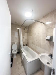 a bathroom with a tub and a toilet and a sink at Stay In Tooting in London