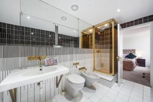 ein Bad mit einem Waschbecken, einem WC und einer Dusche in der Unterkunft Luxurious Apartments in Mayfair in London