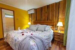 Un dormitorio con una cama con dos cisnes. en Cabañas el Dorado Pucón, en Pucón