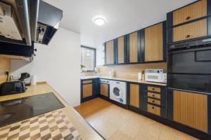 eine große Küche mit Holzschränken und -geräten in der Unterkunft Luxurious Apartments in Mayfair in London