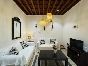 un soggiorno con divano bianco e TV di Villa Vasilia a Líndos