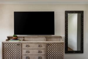 a television on top of a dresser with a mirror at Rancho Bernardo Inn in Rancho Bernardo