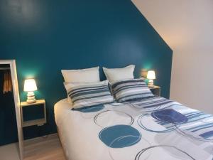 a blue bedroom with a large bed with two lamps at Gîte de la Petite Noërie - 11 personnes in Saint-Georges-le-Fléchard