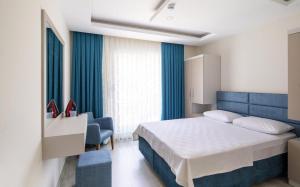 1 dormitorio con cama, escritorio y silla en Tatiliniz için 45 Muhteşem Odalarımız Hazırdır., en Antalya