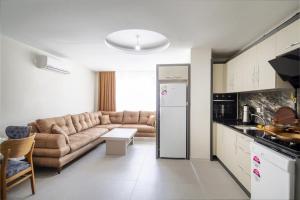 a living room with a couch and a kitchen at Tatiliniz için 45 Muhteşem Odalarımız Hazırdır. in Antalya