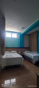 two beds in a room with a window at casa sol residencial tarapoto in Tarapoto