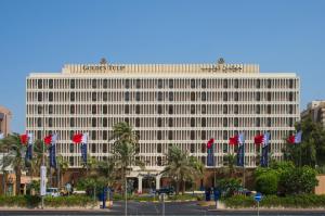 a large building with flags in front of it at Golden Tulip Bahrain in Manama