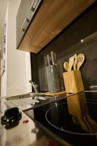 a kitchen counter with a counter top with wooden utensils at Serviced Business Apartment in Lorsch