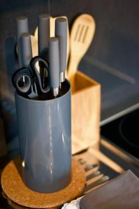 a container of knives and scissors on a table at Serviced Business Apartment in Lorsch