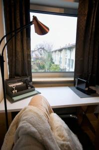 a person sitting in a chair in front of a desk with a lamp at Serviced Business Apartment in Lorsch