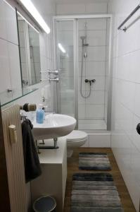 a white bathroom with a sink and a shower at Serviced Business Apartment in Lorsch