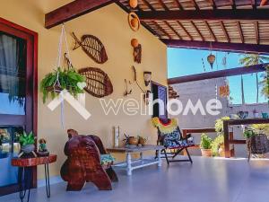 Pokój z krzesłami, stołem i ścianą w obiekcie Linda casa com piscina a 5 minutos da Praia w mieście Pitimbu