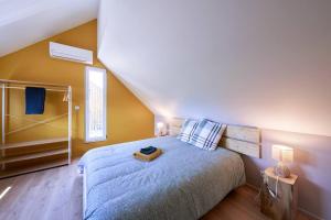 a bedroom with a bed with a blue comforter at Le cépage, au coeur des vignes. in Eguisheim